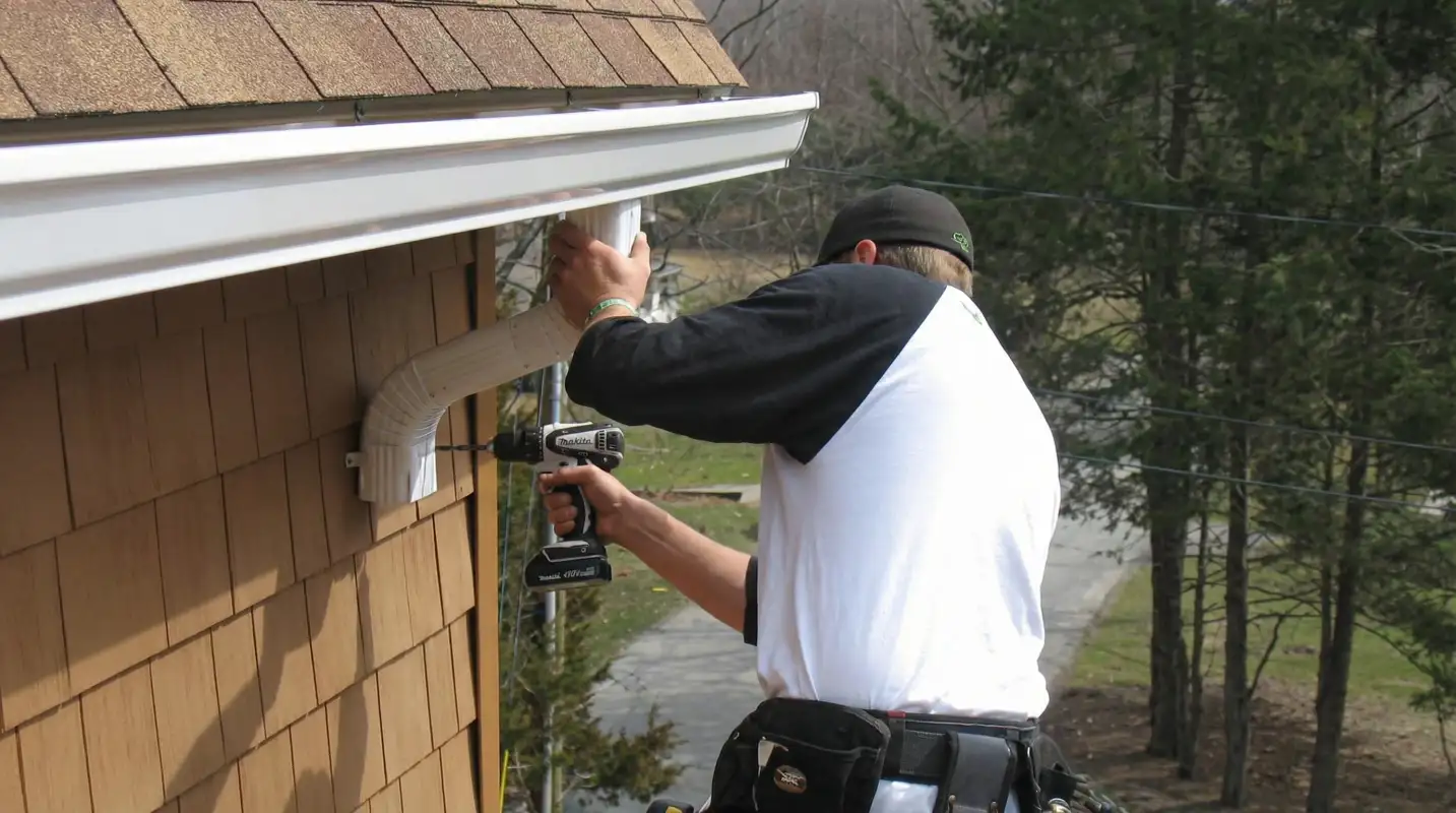 Professional contractor installing tan vinyl siding panels on a residential home exterior in Fort Worth, TX